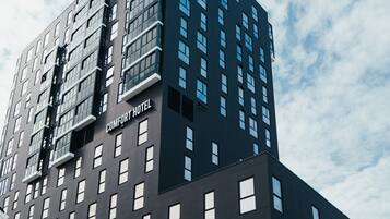 A modern building with a sign reading "COMFORT HOTEL".