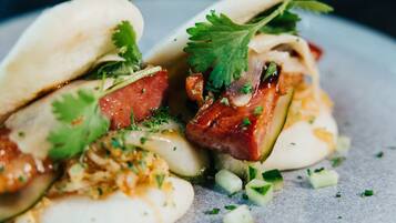 A plate of food with dumplings, meat, and vegetables.