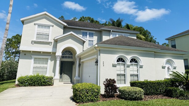 A two-story house with a front entrance, a garage, and a well-maintained lawn. - Villa Hideaway with pool and gamesroom (Davenport)