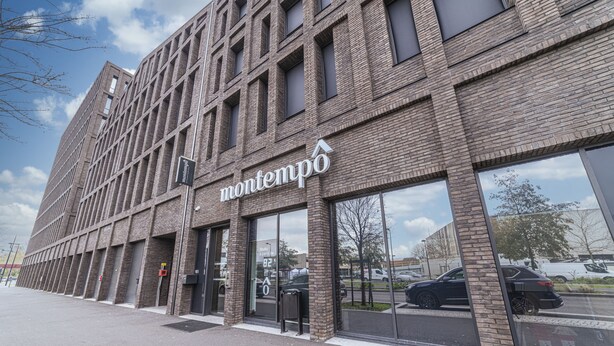 A modern building with a prominent 'montempo' sign, large windows, and a brick facade. - Montempô Bordeaux centre - Bassins à flot (Bordeaux)