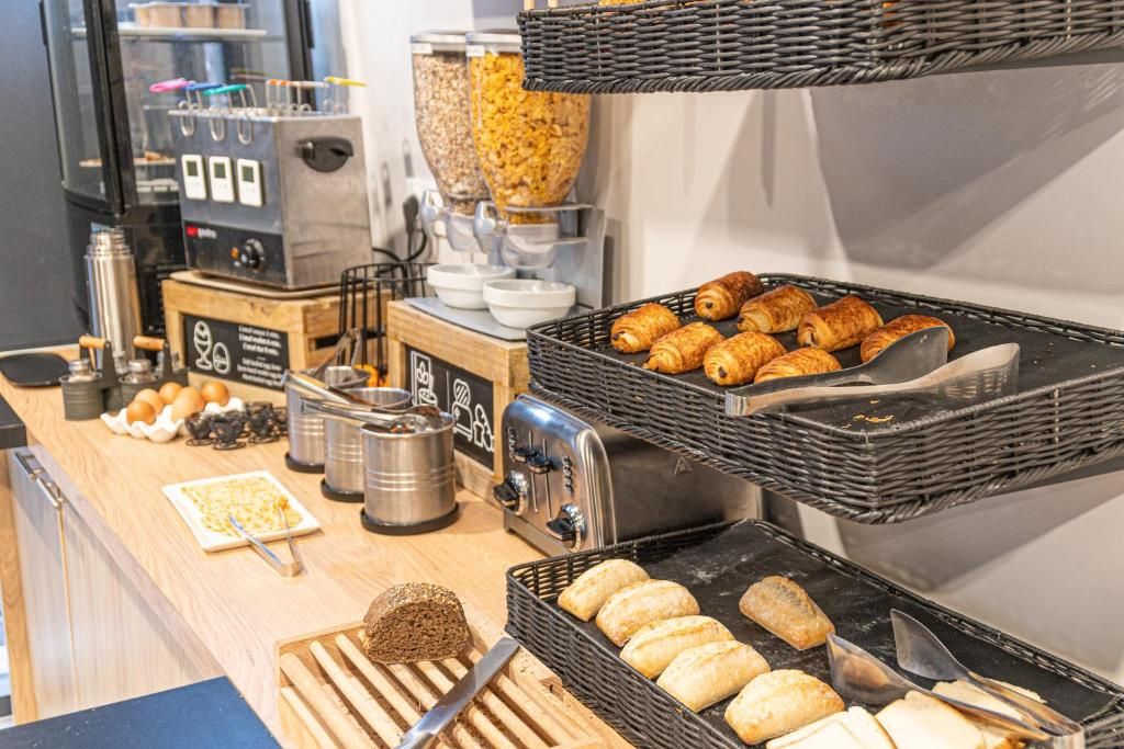 Ein Frühstücksbuffet mit verschiedenen Backwaren, einer Kaffeemaschine und einem Toaster.