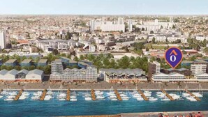 A coastal cityscape with a marina filled with boats, a large hotel complex with multiple buildings, and a prominent church in the background. - Montempô Bordeaux centre - Bassins à flot (Bordeaux)