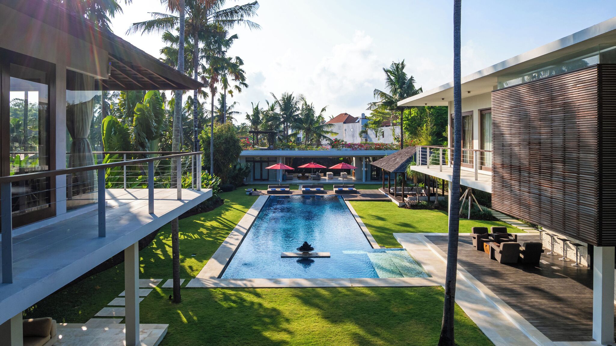 Ein moderner Poolbereich mit freiem Blick auf den Pool, Liegestühle und eine überdachte Sitzgelegenheit.