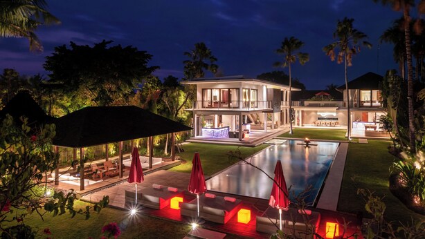 A modern two-story house with a swimming pool, outdoor seating, and a well-lit patio area. - Villa Kalyani (Canggu)