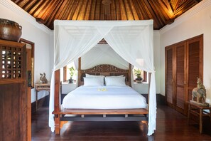 A large bed with a canopy, wooden headboard, and white bedding.