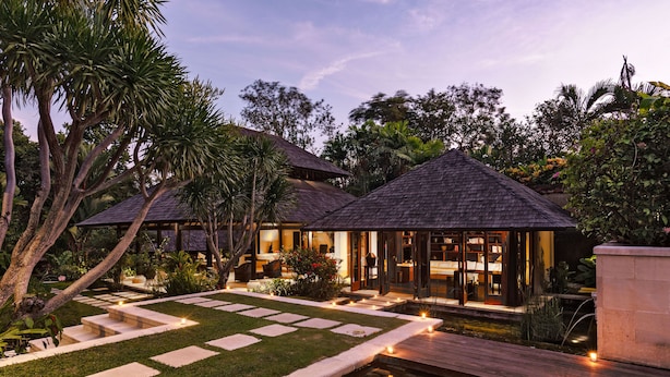 A resort with multiple buildings, a well-maintained garden, and a water feature.