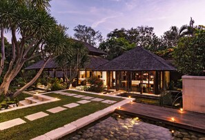 A resort with multiple buildings, a well-maintained garden, and a water feature.