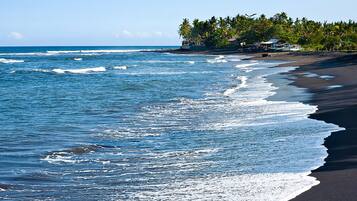 En la playa, sillas reclinables de playa, sombrillas, toallas de playa