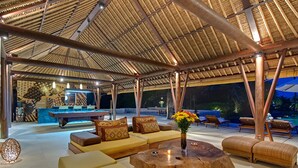 An outdoor lounge area with a pool table, sofas, and a wooden coffee table. - Villa Samadhana (Sukawati)