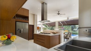 Cocina moderna con una isla central, electrodomésticos integrados y vistas a un espacio exterior.