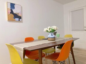 Un comedor con una mesa, sillas y un florero.