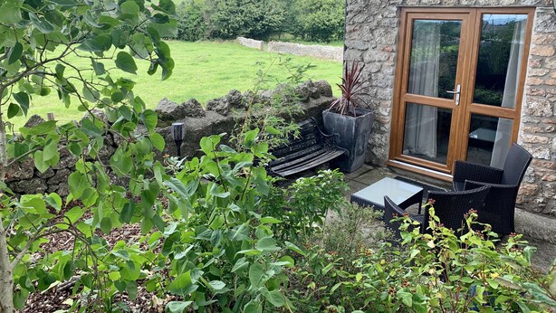 A stone building with a large window overlooking a green landscape. - The Stables, Lovely Country Apartment in a Converted Barn (Wells)