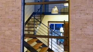 A staircase with a wooden finish and metal railings, leading to an upper floor. - Villa Petra (Nin)