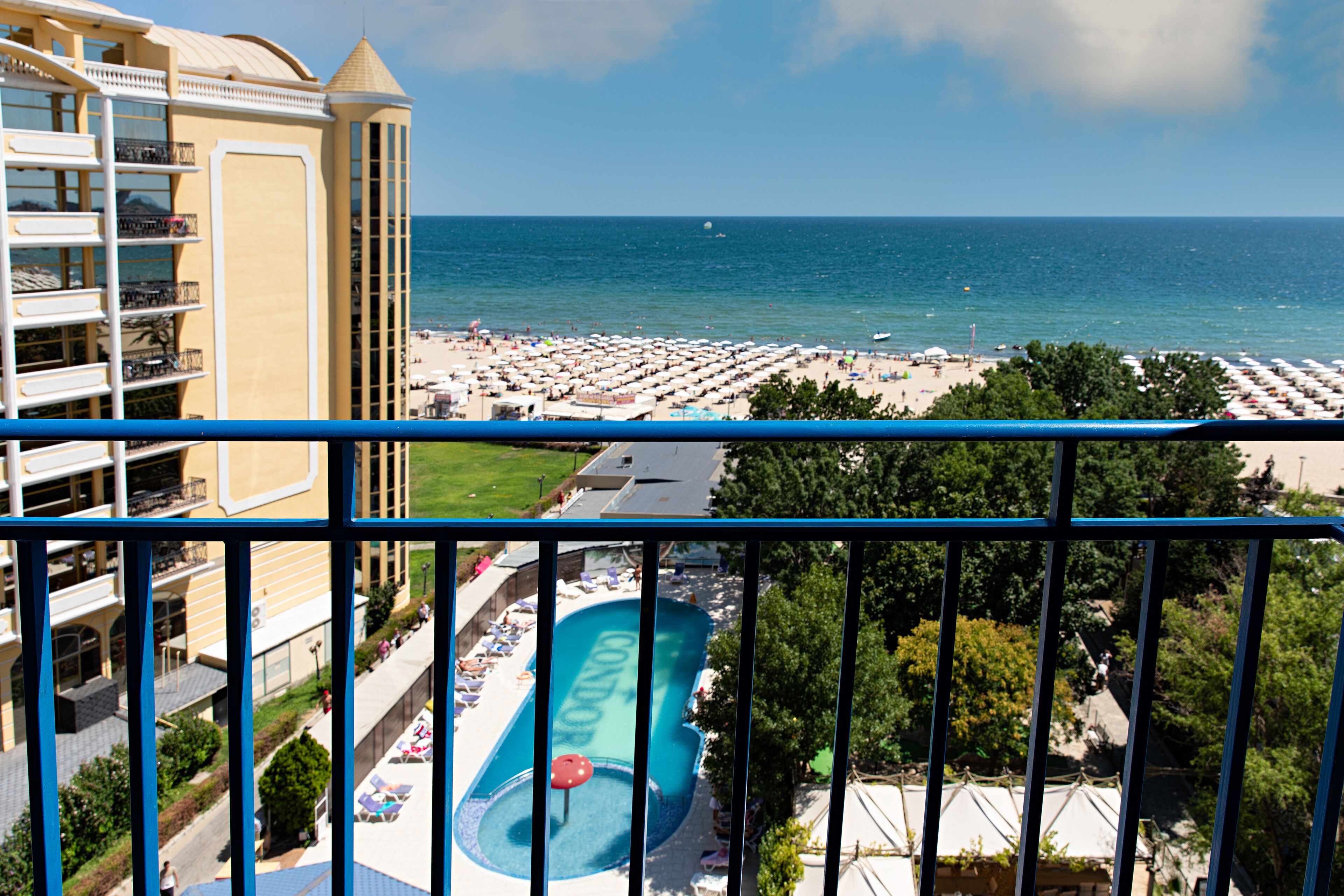 A hotel with a pool, beach, and ocean view.