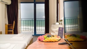 A hotel room with a bed, a table with fruit and a glass, and a view of the beach through the balcony doors. - MPM Hotel Condor - All Inclusive Light (Sunny Beach)