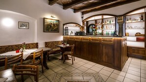 A traditional interior with wooden furniture, a bar area with bottles, and a tiled floor. - Atrium Penzion (Poprad)
