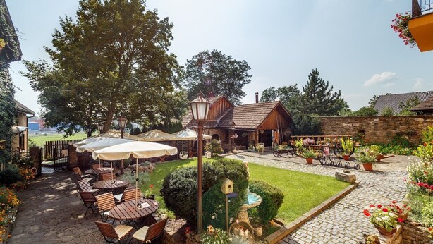 A courtyard with outdoor seating, a fountain, and a well-maintained lawn. - Atrium Penzion (Poprad)