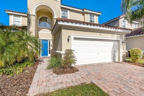 A two-story house with a white garage door, a blue door, and a number '712' on the garage.