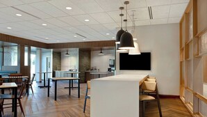 A modern interior with a central island, dining tables, chairs, and pendant lighting. - Fairfield Inn & Suites by Marriott St. Paul Eagan (Eagan)