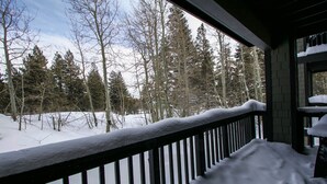 A snow-covered deck with a railing overlooking a forested area. - On Sierra Star Golf Course, Washer/Dryer, Quiet Location & On-site Pool (Mammoth Lakes)