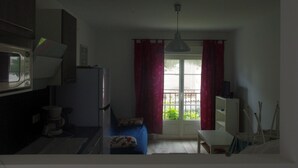 A compact kitchen with a microwave, a coffee maker, and a small dining area with a table and chairs. - T3 1st floor of the villa of the sea (Hyères)