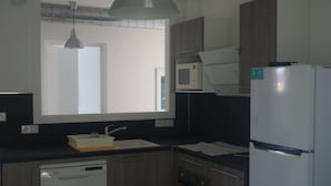 A compact kitchen with a dishwasher, microwave, and refrigerator. - T3 1st floor of the villa of the sea (Hyères)