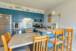 A kitchen with blue cabinets, a refrigerator, a microwave, and a coffee maker. - Blue Surf 14A- Steps to the beach (Miramar)