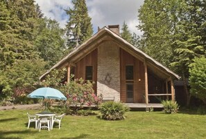 A rustic cabin with a stone facade, wooden beams, and a sloped roof.