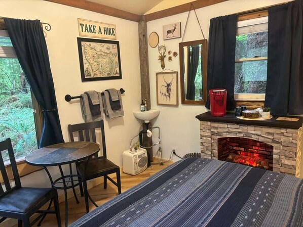 A cozy room with a fireplace, a map on the wall, and a table with chairs.