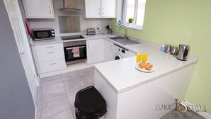 A compact kitchen with white cabinets, a microwave, a toaster, a sink, and a small window. - 6 X APARTMENTS IN 1 BLOCK JUST OUTSIDE THE CITY ⭐MINUTES WALK FROM SHOPS⭐ APT#4 (Newcastle Upon Tyne)