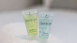 Twee flessen 'Just for you' shampoo en conditioner, en bad- en douchegel, op een witte ondergrond.