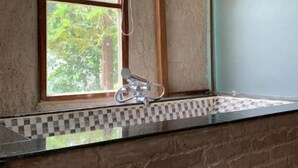 A bathroom with a window, a shower, and a tiled backsplash. - Rustic Charm Wayanad - The Stump (Treetop Suite) (Appapara)