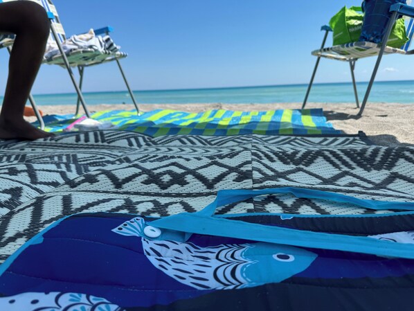 Relax on the beach with comfortable chairs and colorful towels.