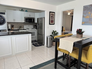 Enjoy cooking in this well-equipped kitchen with stainless steel appliances, a central island, and a dining area.