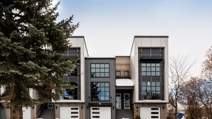 A modern multi-story residential building with large windows, a garage, and a snow-covered driveway. - Teddys Townhouse- New Modern Townhome in Belgrade with lots of natural light! (Belgrade)