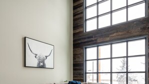 A modern living room with a sectional sofa, a wooden coffee table, and a large window with a view of the outdoors. - Teddys Townhouse- New Modern Townhome in Belgrade with lots of natural light! (Belgrade)