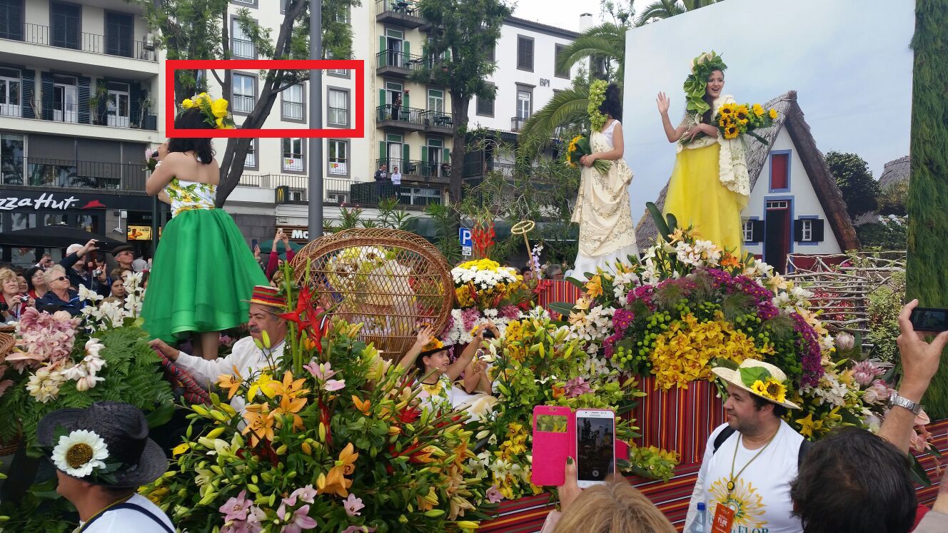 A parade with participants in costumes and floral arrangements.