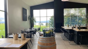 A restaurant with large windows, a wooden barrel, and outdoor views.