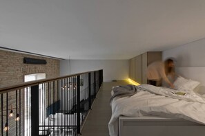 A modern bedroom with a bed, a balcony, and a city view. - Luxury 1-bed Apartment in Vilnius Oldtown (Vilnius)