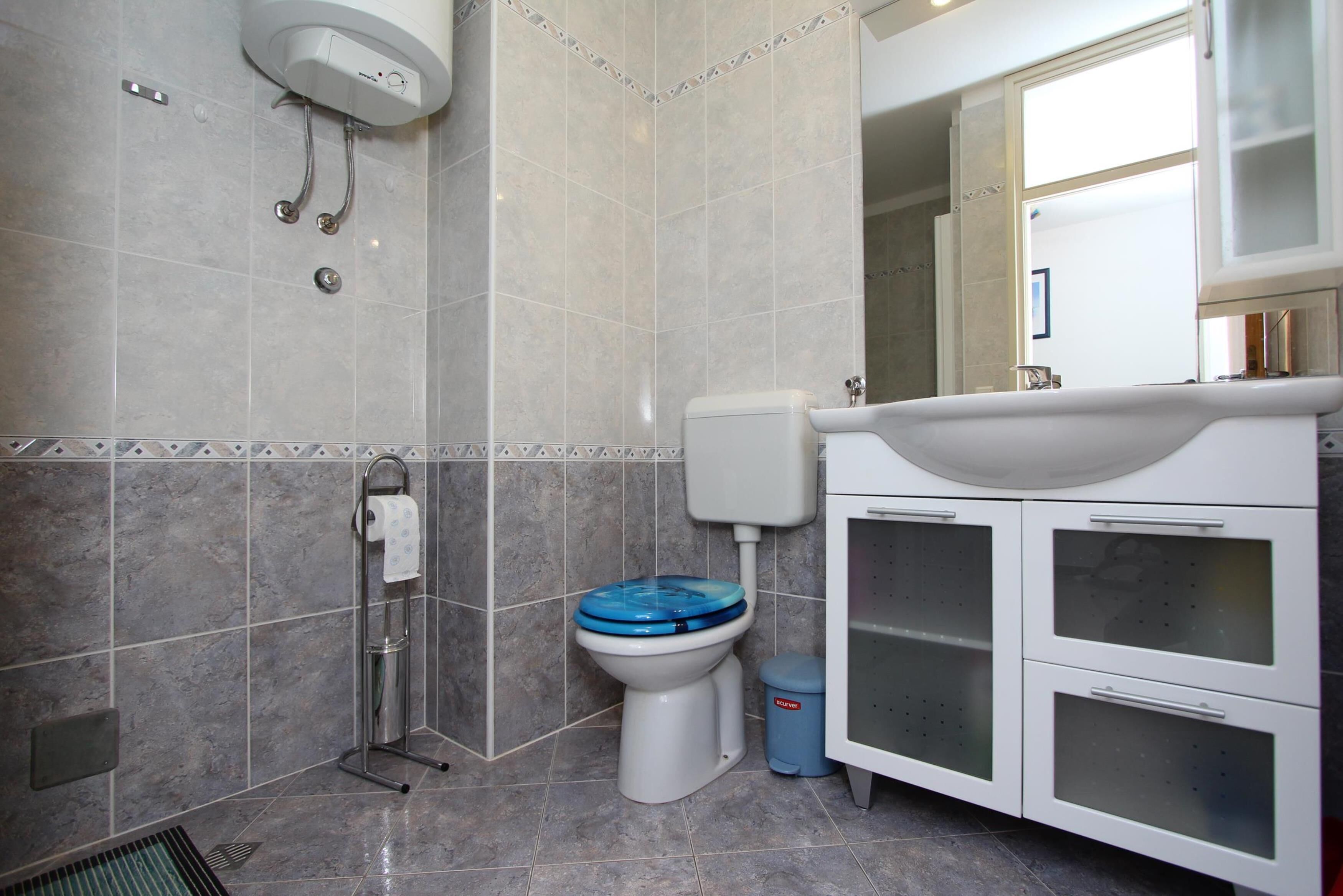 A bathroom with a toilet, bidet, and a sink with cabinets.