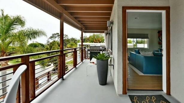Un balcon abrité, doté d’un barbecue, d’une plante en pot et offrant une vue sur l’extérieur.