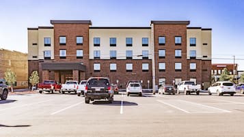 Ein mehrstöckiges Hotel mit Parkplatz davor.