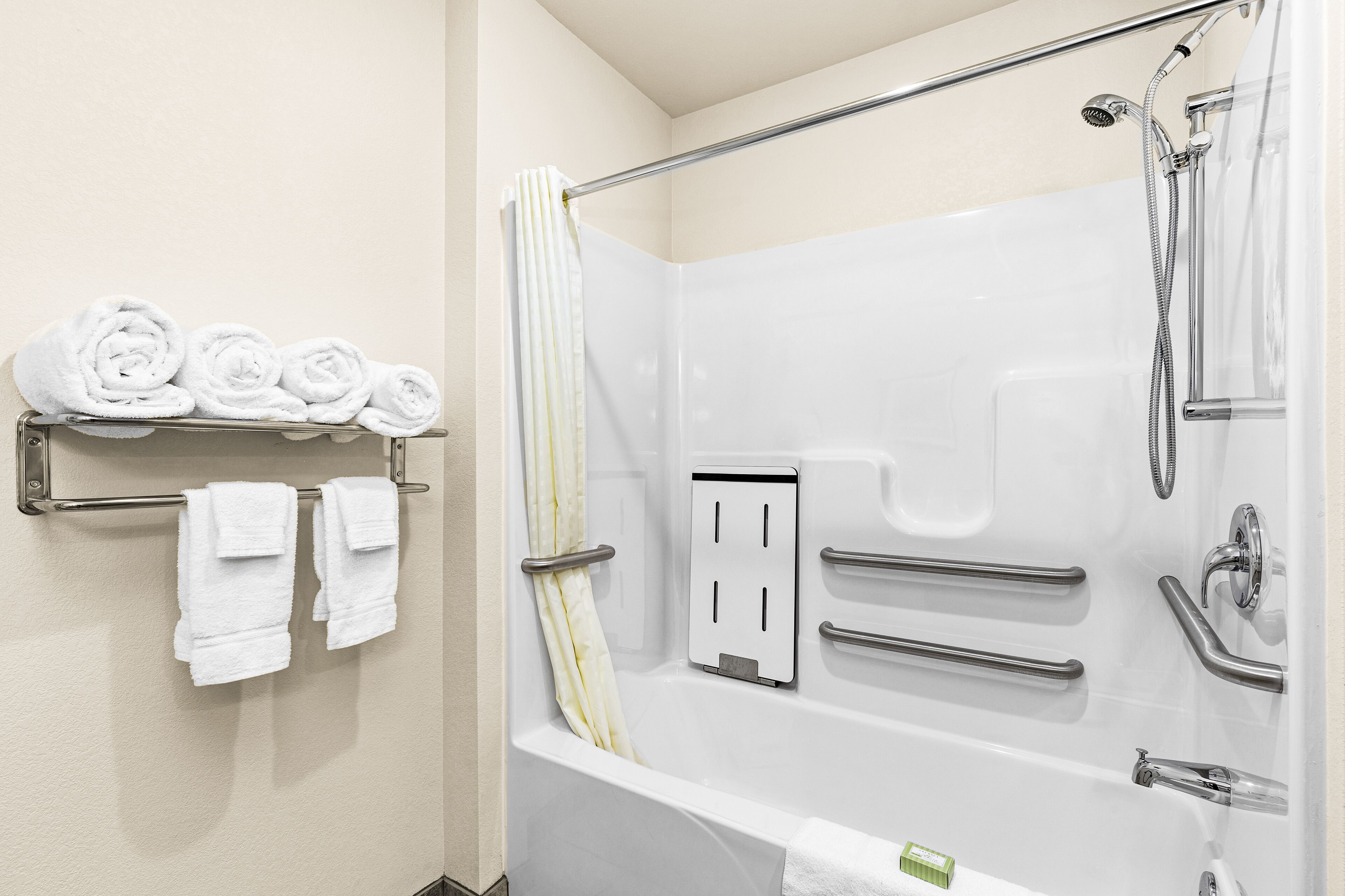 Un baño moderno con bañera, ducha y perchero para toallas.