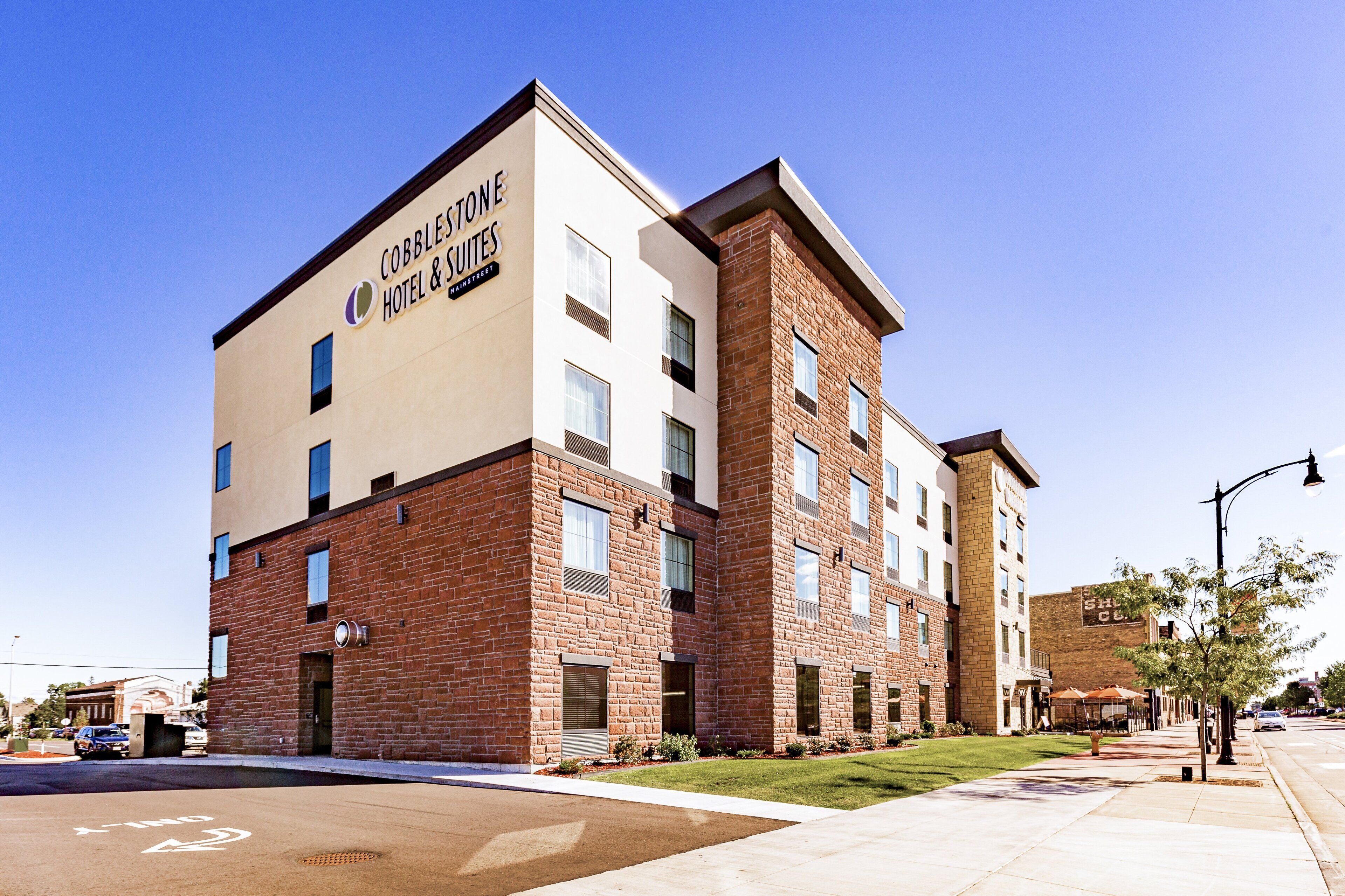 A modern Cobblestone Suites hotel with a brick facade and multiple windows.
