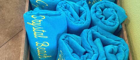 A wooden box filled with rolled blue towels.