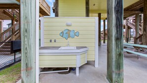 Ein Badezimmer mit Holzbalkon, einem Waschbecken und einem Wandgemälde mit Fischen.