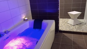 A modern bathroom with a bathtub, a small white pedestal, and a tiled floor. - Le loft Concarneau (Concarneau)