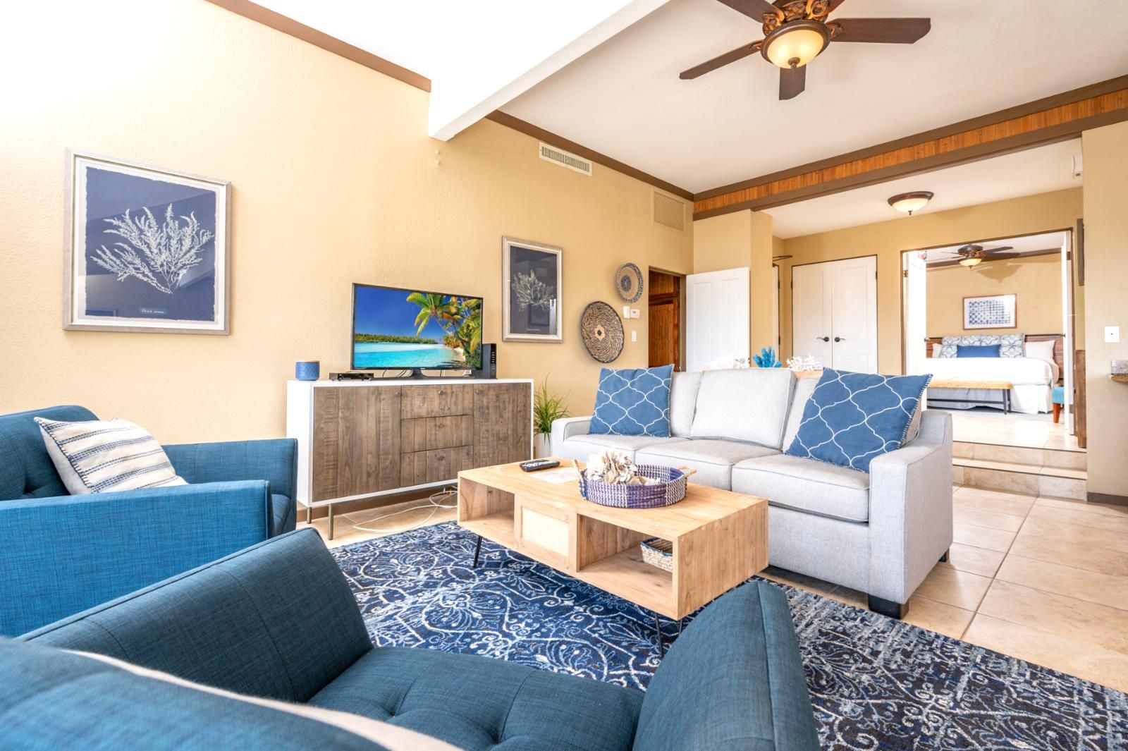 Ein Wohnzimmer mit Fernseher, Sofas, einem Couchtisch und einem Essbereich mit Tisch und Stühlen.