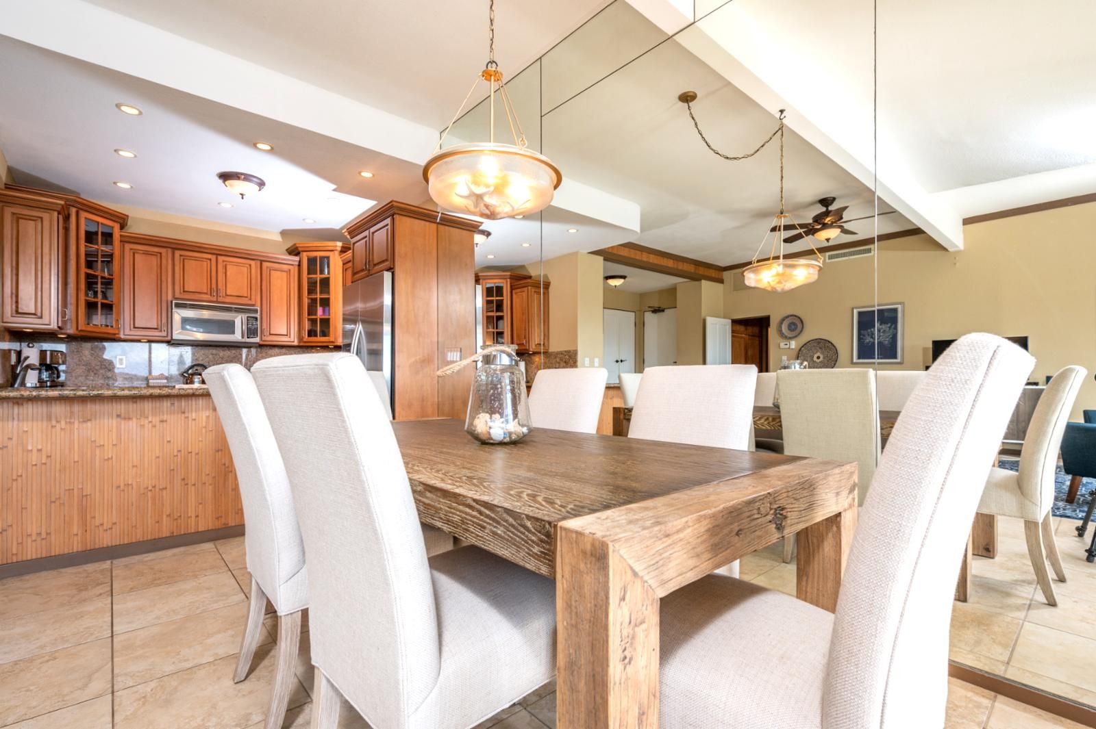 Una cucina moderna con mobili in legno, un'isola centrale e un'area pranzo con tavolo e sedie in legno.