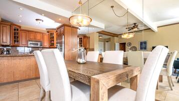 Una cucina moderna con mobili in legno, un'isola centrale e un'area pranzo con tavolo e sedie in legno.